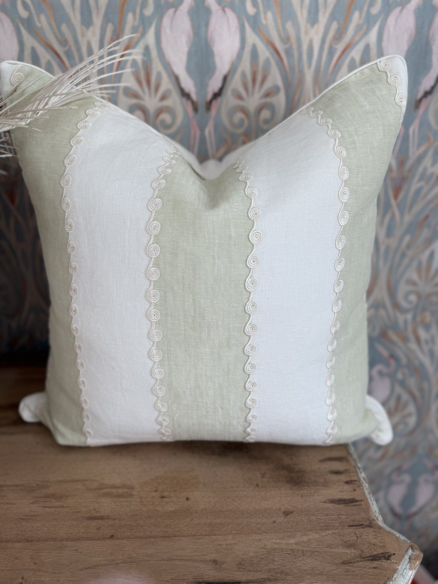 Ashmore soft green and ivory linen stripe pillow with embroidered scroll detail against heron wallpaper