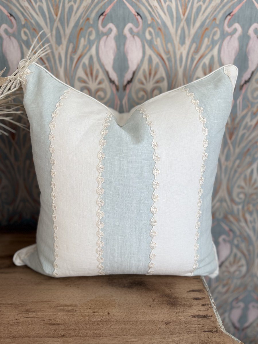 Ashmore soft blue and ivory linen stripe pillow with embroidered scroll detail against heron wallpaper