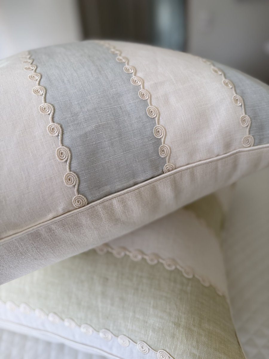 Ashmore pillows stacked showing embroidered ivory scroll stripes and ivory piping detail