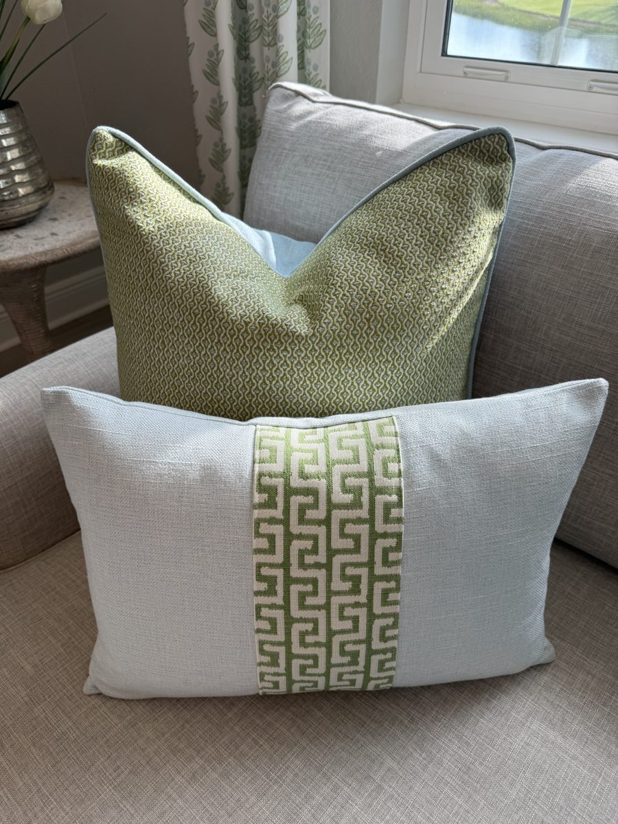 Athena lumbar pillow paired with green pillow on armchair