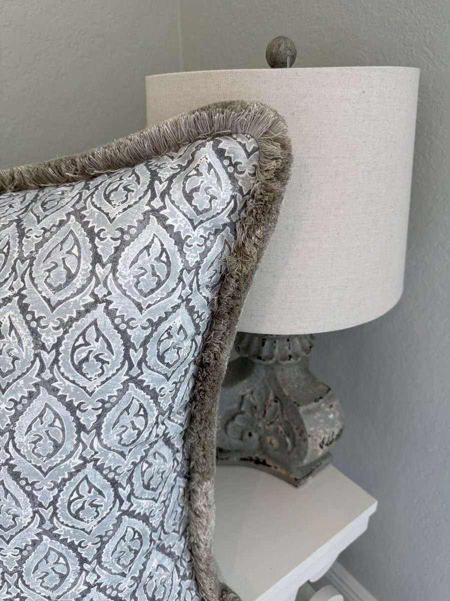 Broadway blue grey block print pillow with fringe styled beside lamp