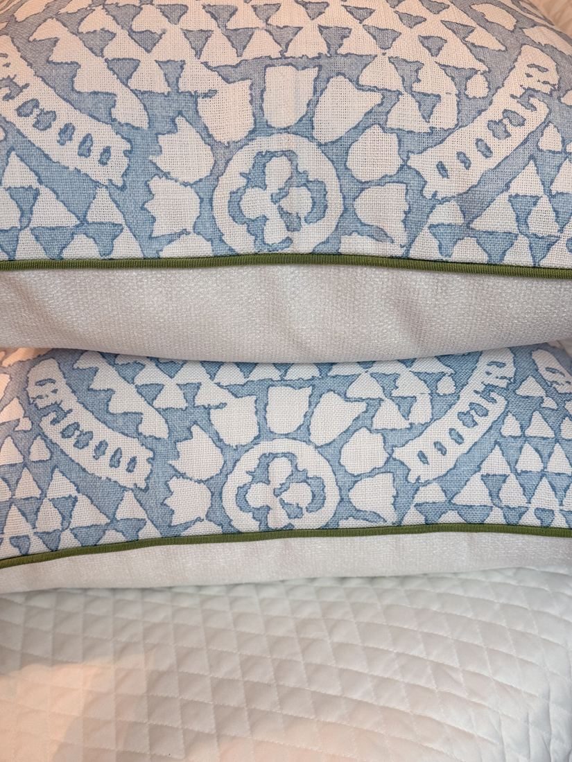 Stacked Chamomile pillows with green trim and white backing