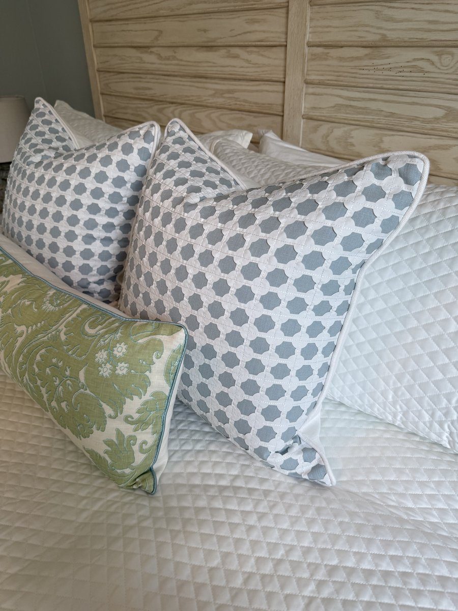 Cothay lattice pillows styled on bed with green damask lumbar pillow