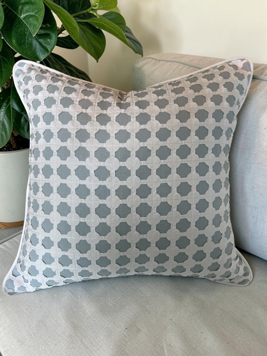 Cothay soft blue Kravet lattice pillow with white piping styled on sofa with plant