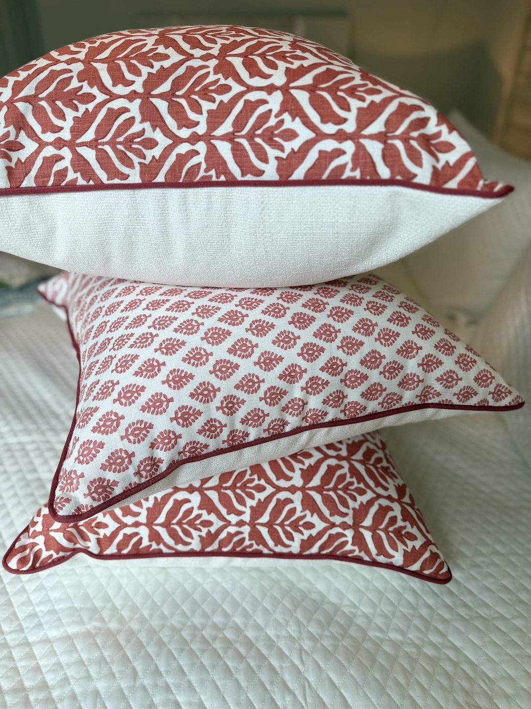 Devi pillow stacked showing red trim and white back