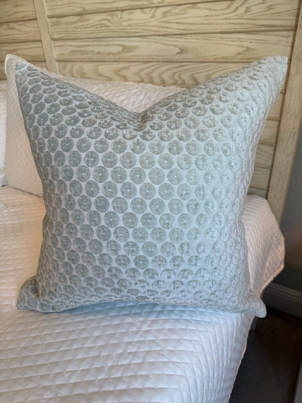 Dotted mist blue velvet pillow styled on bed