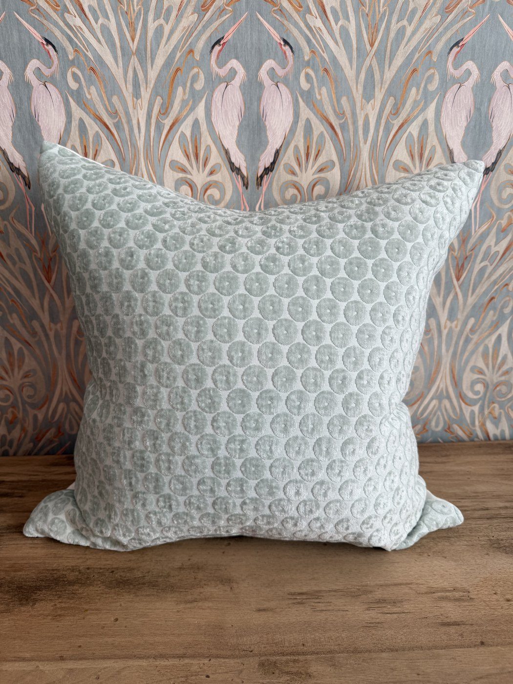 Dotted mist blue cut velvet pillow with heron wallpaper backdrop
