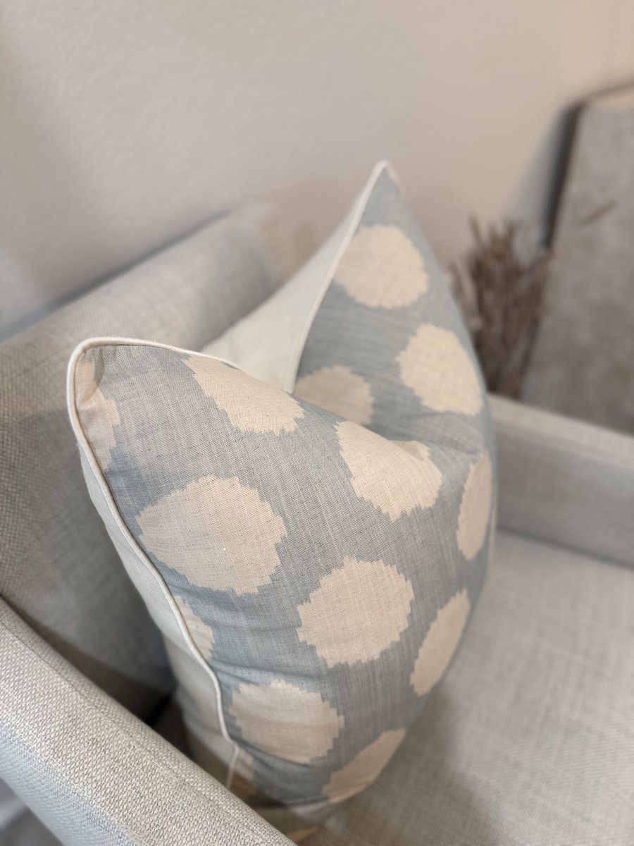Duckie blue ikat dot pillow angled view on armchair showing ivory backing