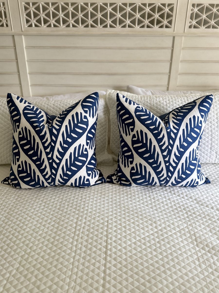 Pair of Ginger Thibaut palm pillows styled on bed by PepperTree Designs