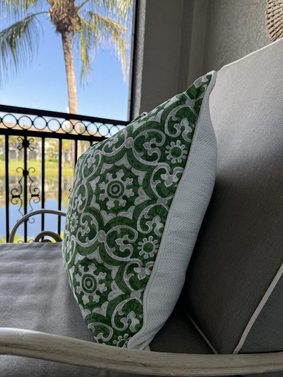 Hampton green medallion pillow side view on lanai with palm view