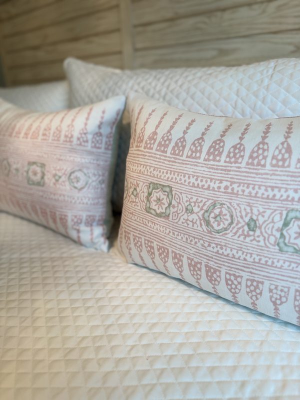 Javanese Stripe blush pillows styled on bed