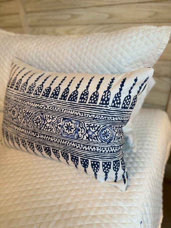 Javanese Stripe navy lumbar styled with navy diamond pillow on bed