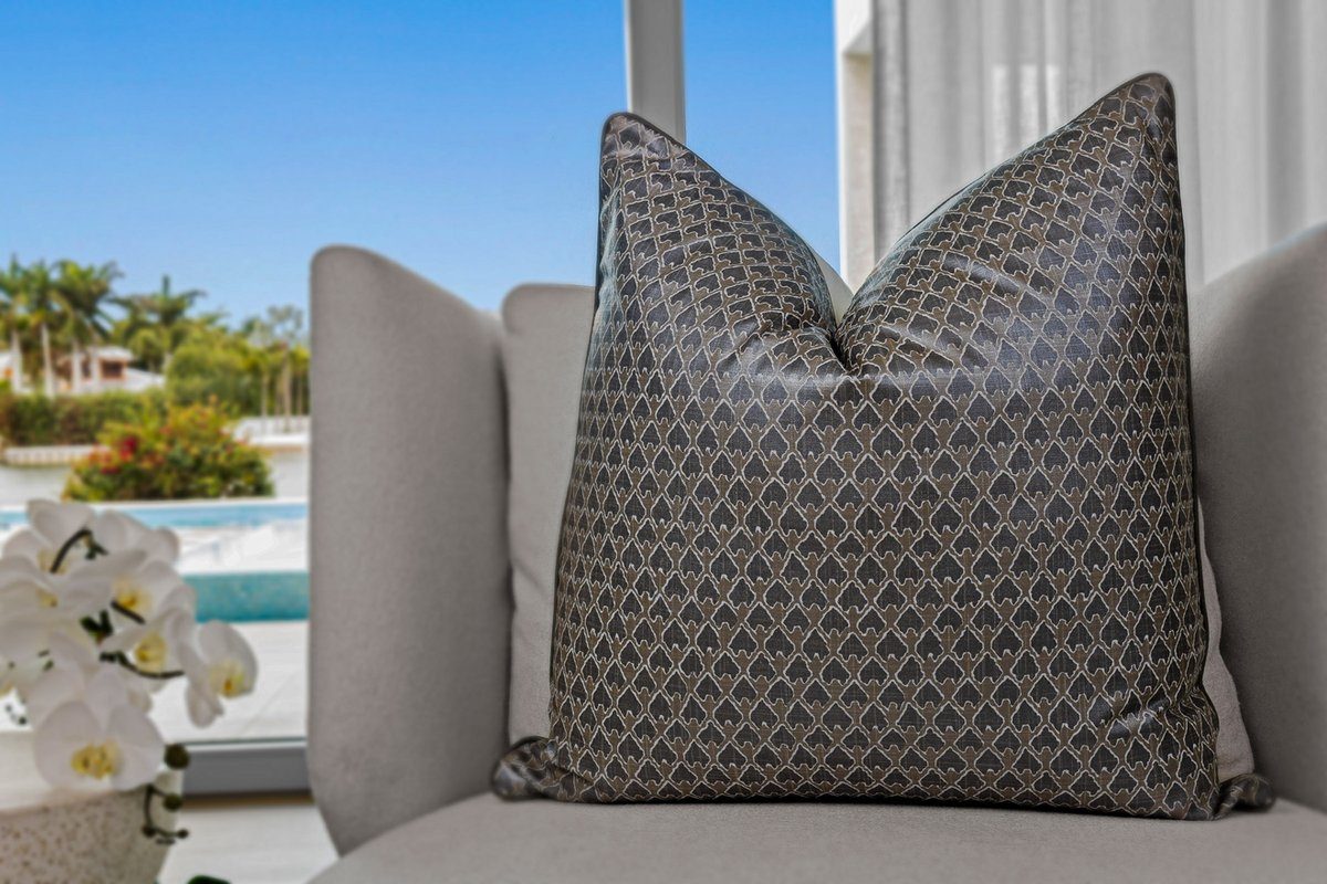 Kanapaali pillow styled on chair with pool and palm view