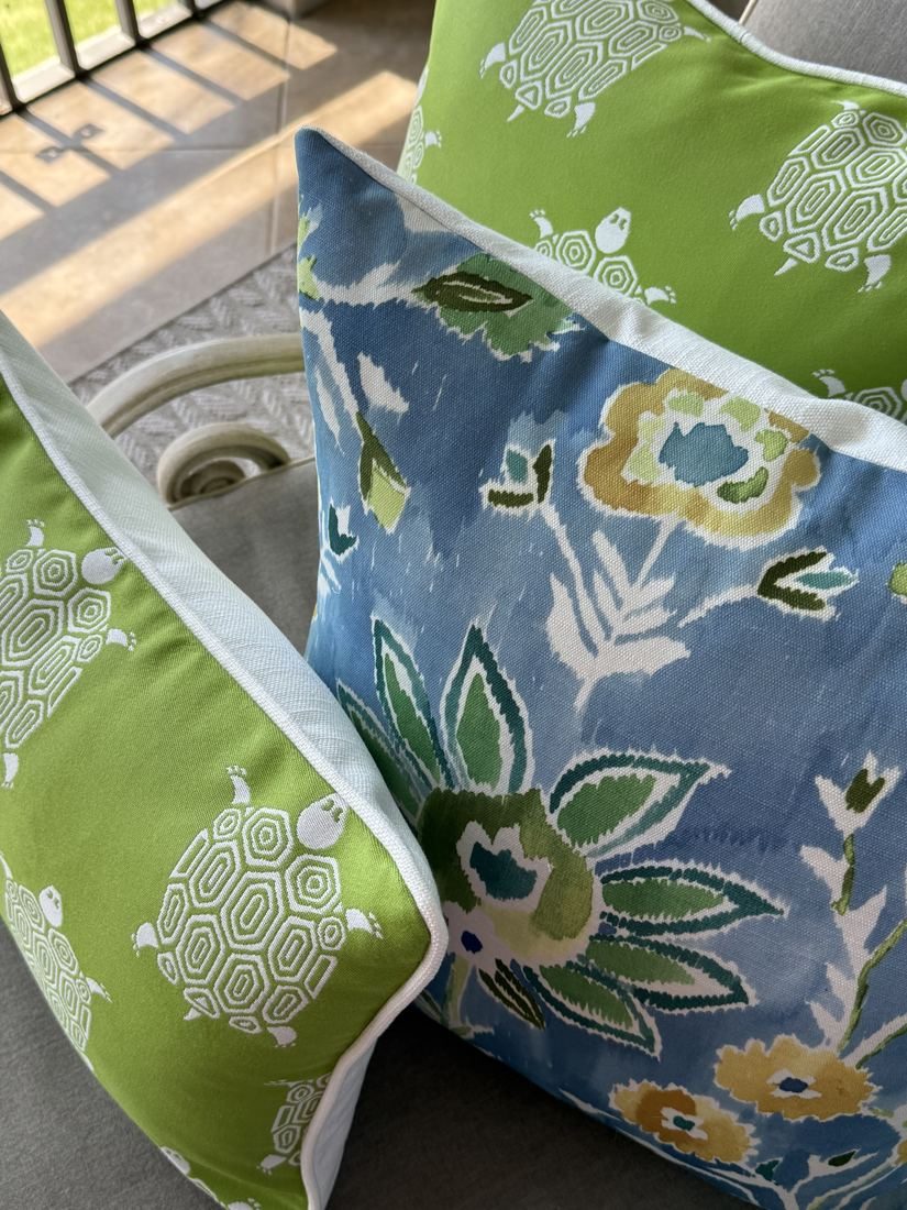 Lilia Thibaut floral pillow with green turtle pillows