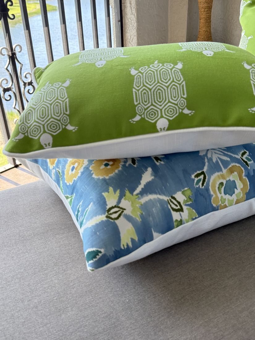 Lilia navy indoor outdoor pillow stacked on porch