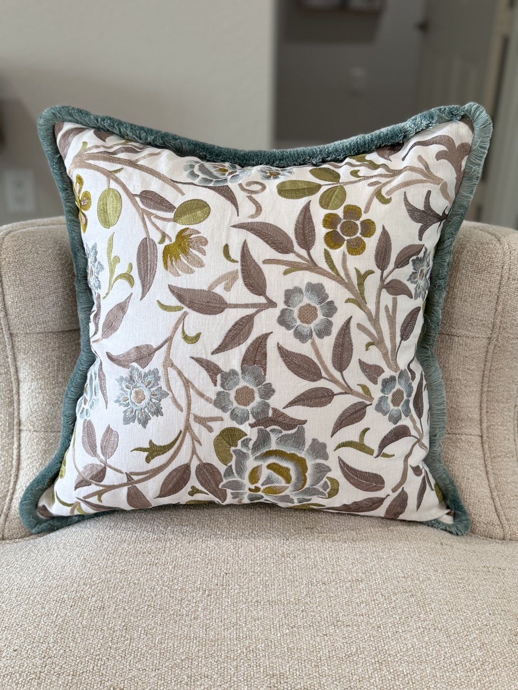 Meadowfield embroidered floral pillow with brushed blue fringe on armchair by PepperTree Designs