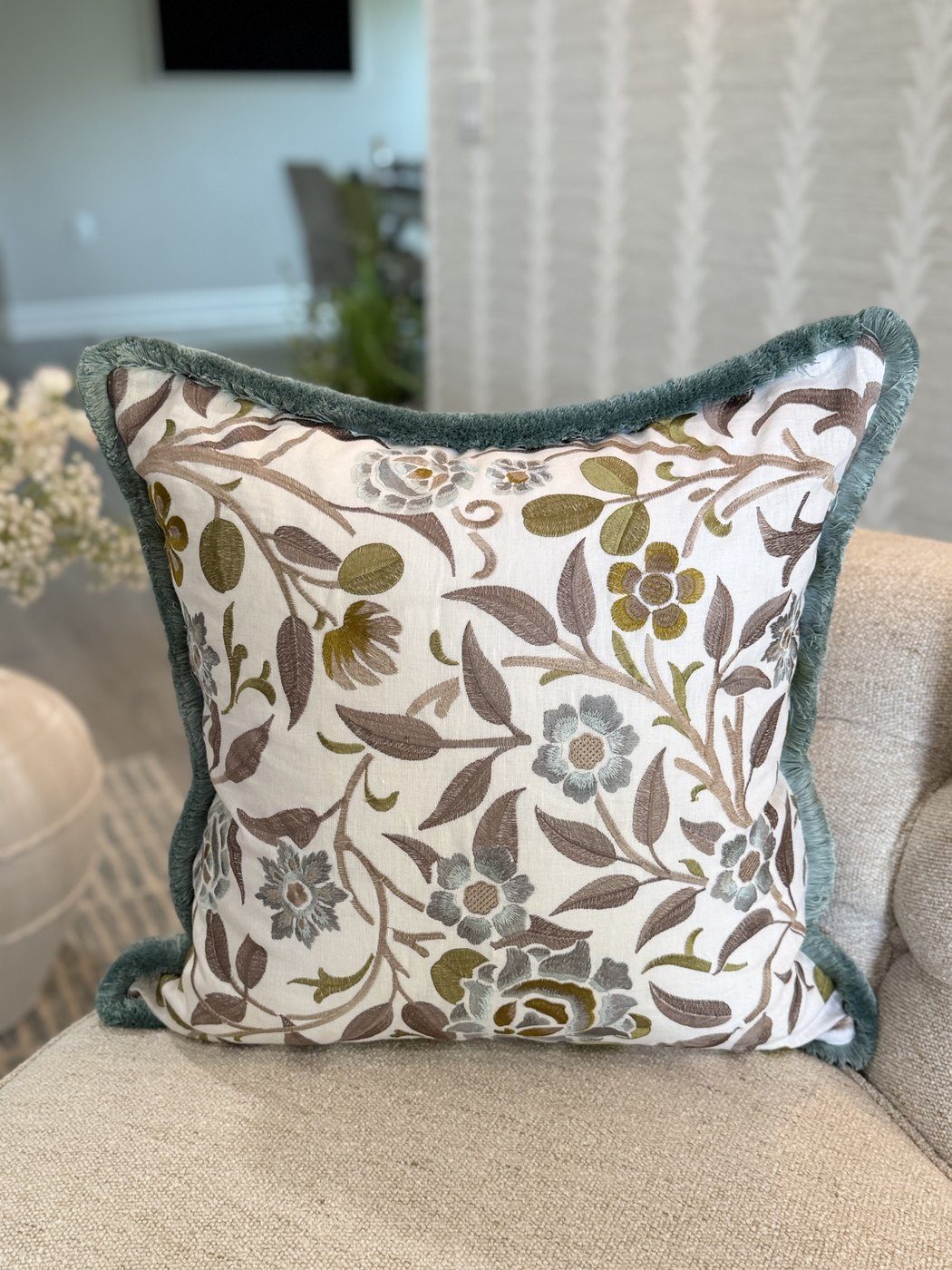 Meadowfield crewel embroidered floral pillow with brushed blue fringe styled on chair