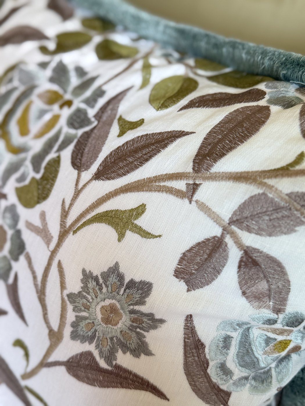Meadowfield pillow embroidery detail in sage, taupe, and citrine with brushed blue fringe