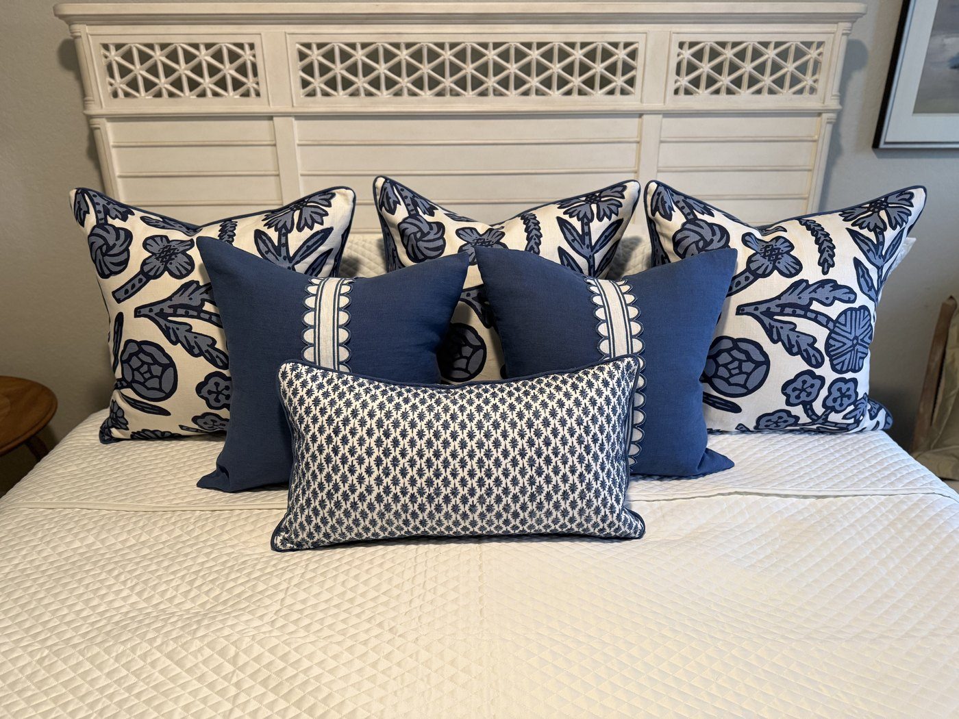 Pair of Navy Scallop pillows with blue and white floral pillows on bed