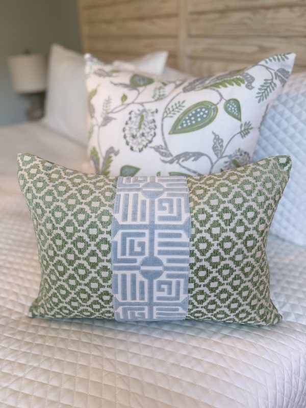Green lumbar with spa blue Labyrinth stripe front view on bed