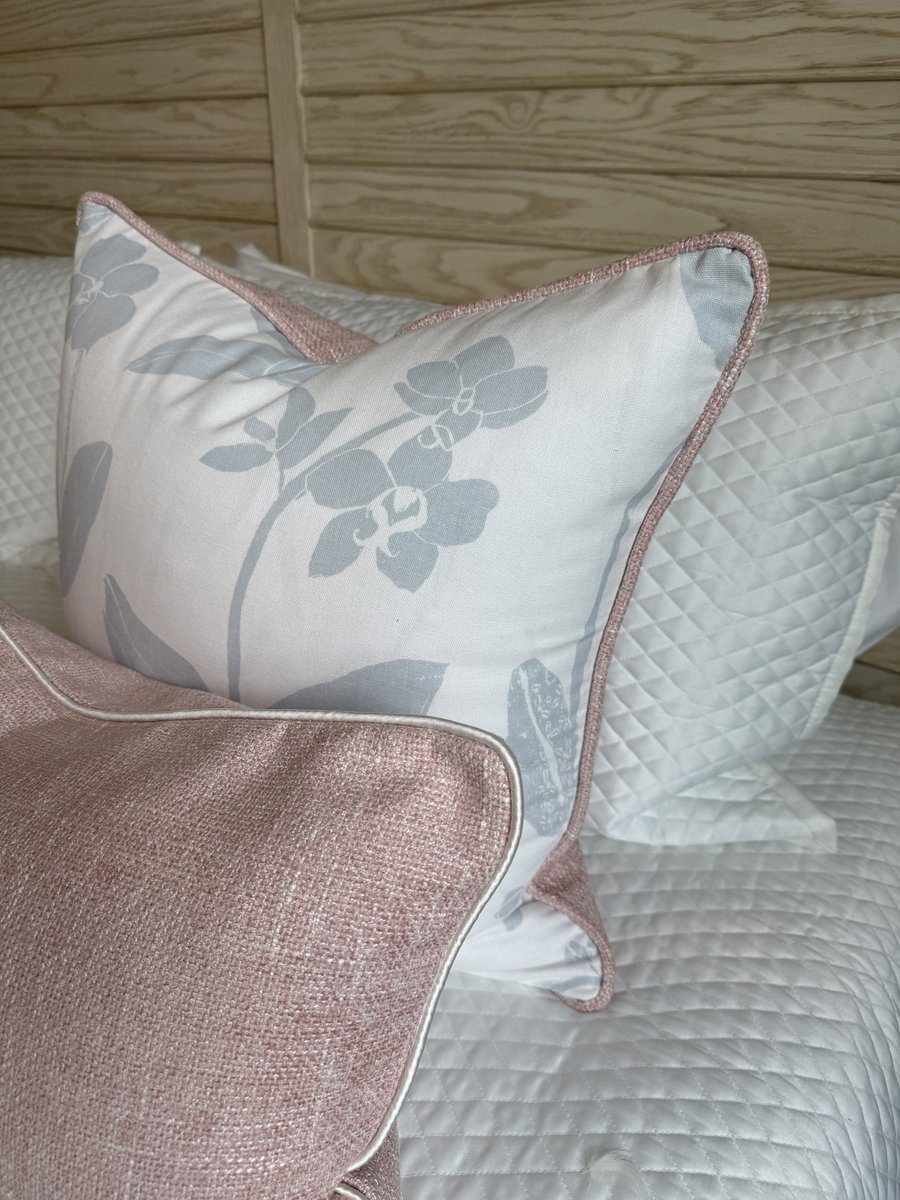 Orchids blue floral pillow with blush piping styled on bed with blush companion pillow