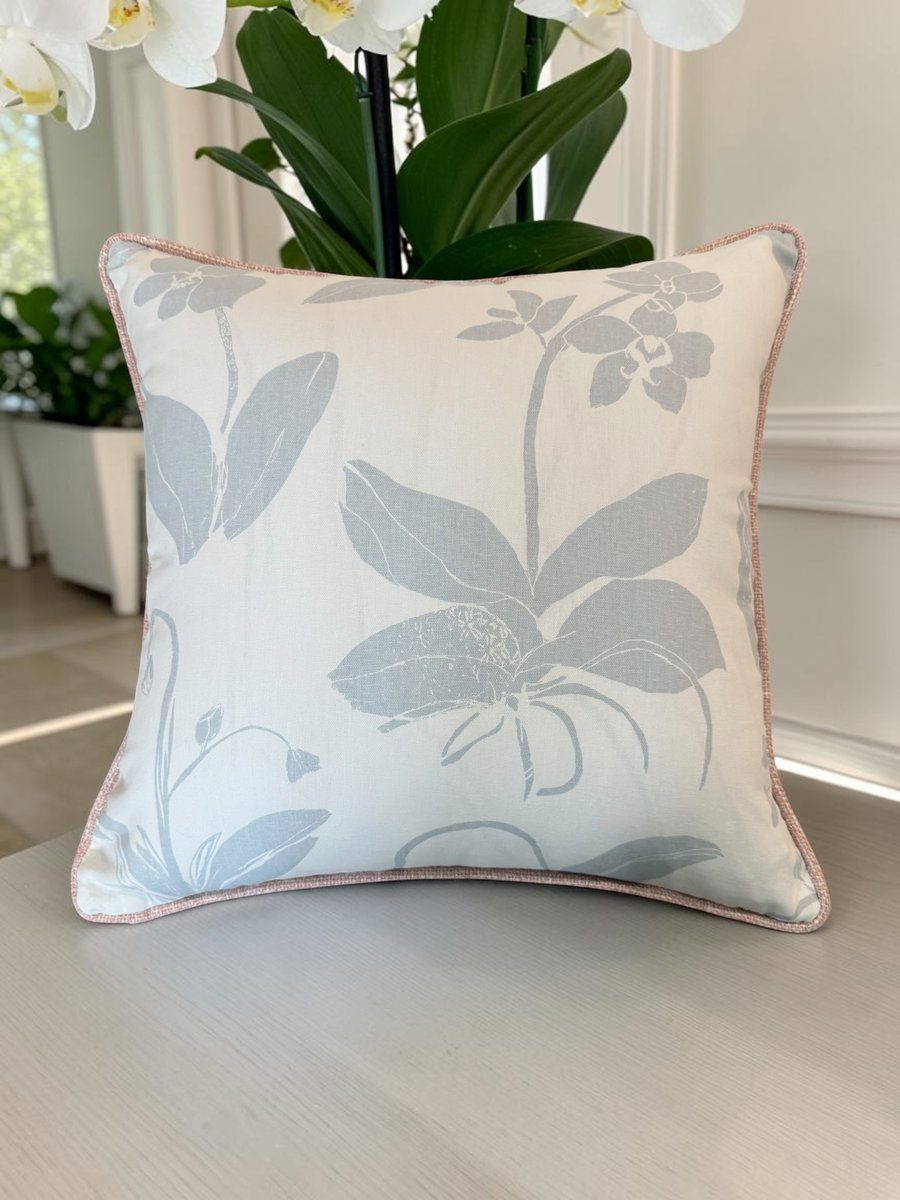 Orchids blue floral pillow with blush piping styled with white orchid plant on console