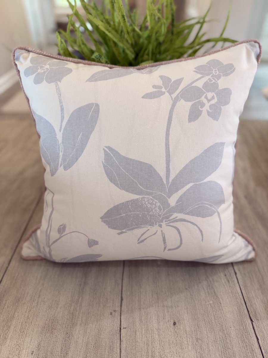 Orchids soft blue floral pillow front view with blush woven piping on wood floor