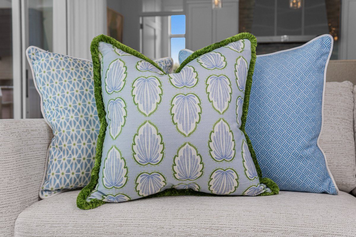 Palmer styled on sofa between blue pillows