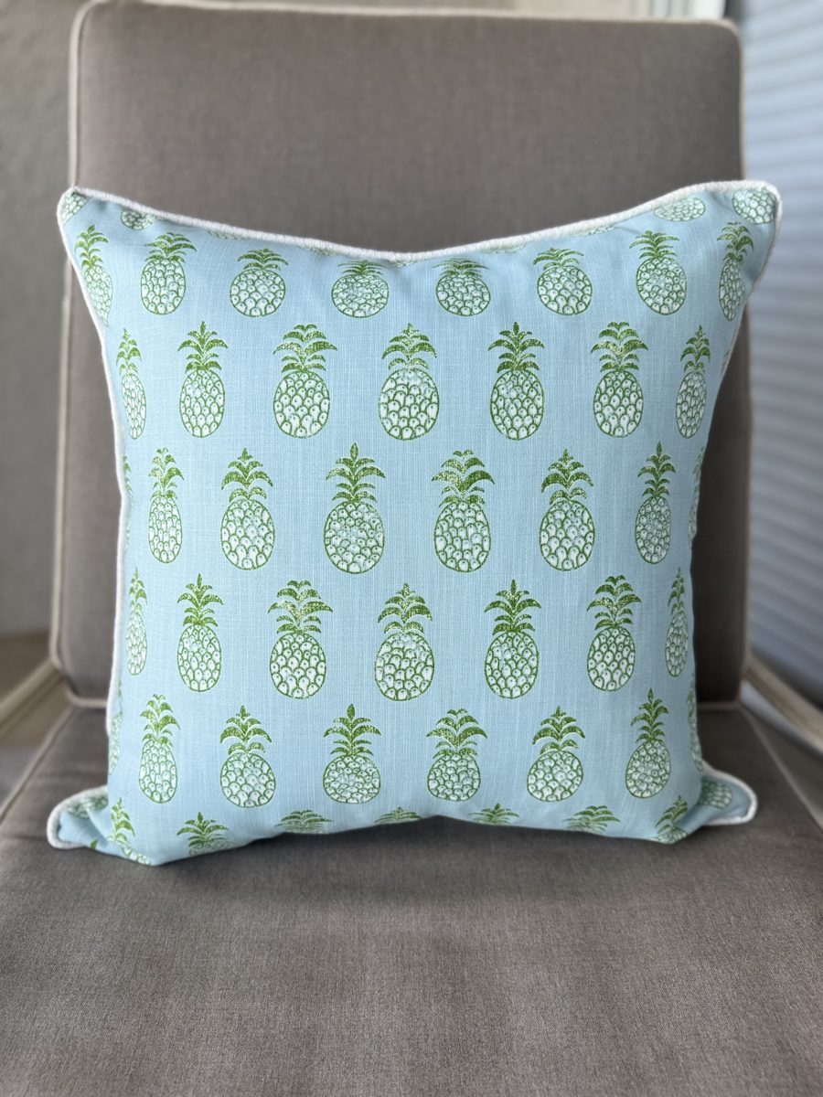Pina Cove blue green pineapple print pillow front view on chair