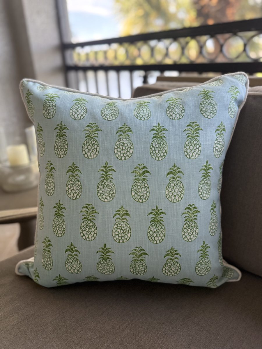 Pina Cove Schumacher pineapple pillow on lanai with palm view