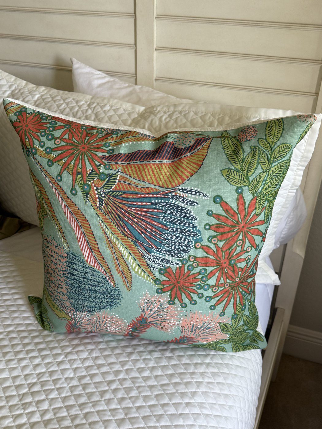 Protea indoor outdoor pillow with white backing styled on bed