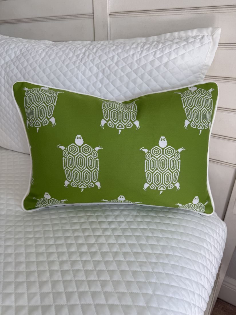 Turtle Bay kiwi lumbar pillow with white trim on bed