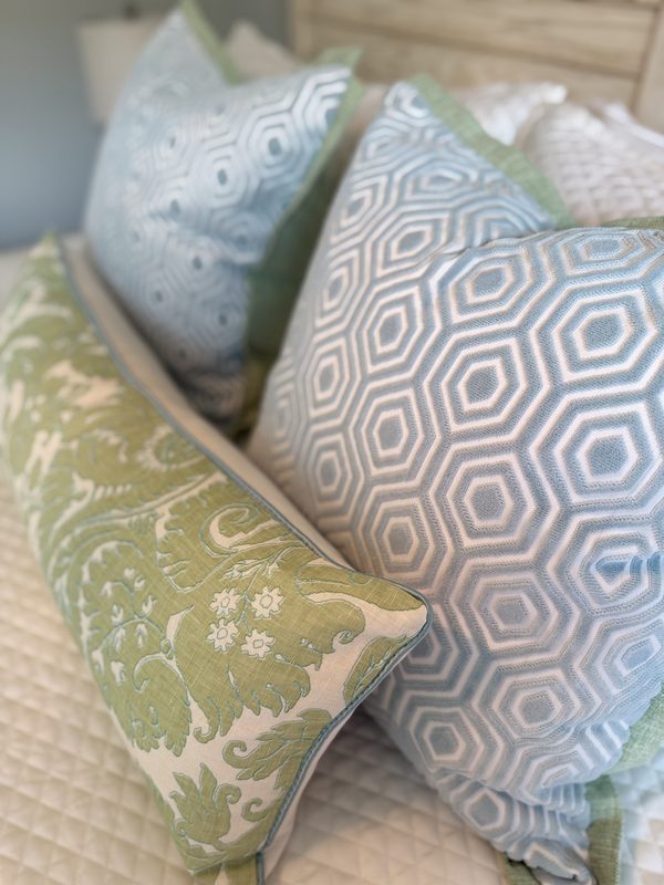 Hexagon velvet pillow styled with green damask lumbar on bed